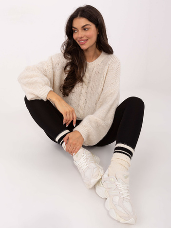 Jasnobeżowy sweter oversize z warkoczem